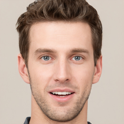 Joyful white young-adult male with short  brown hair and grey eyes