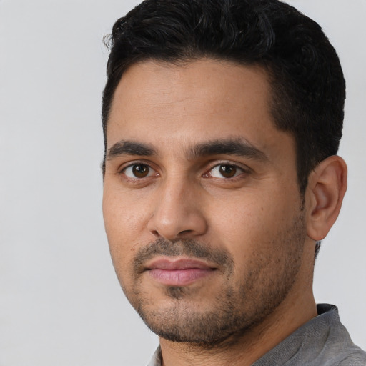 Joyful latino young-adult male with short  black hair and brown eyes