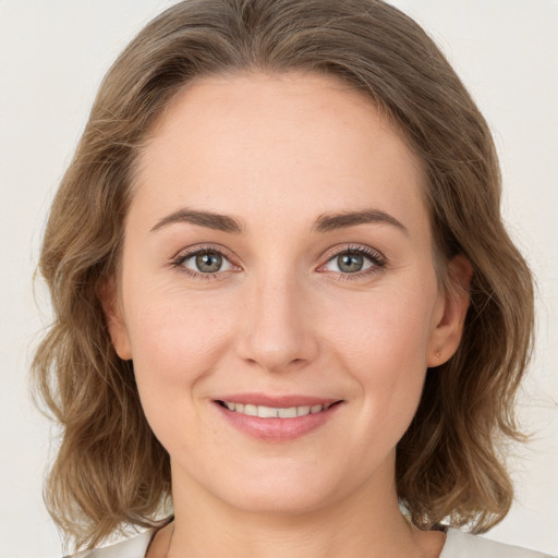 Joyful white young-adult female with medium  brown hair and green eyes