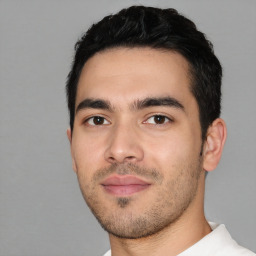 Joyful white young-adult male with short  black hair and brown eyes