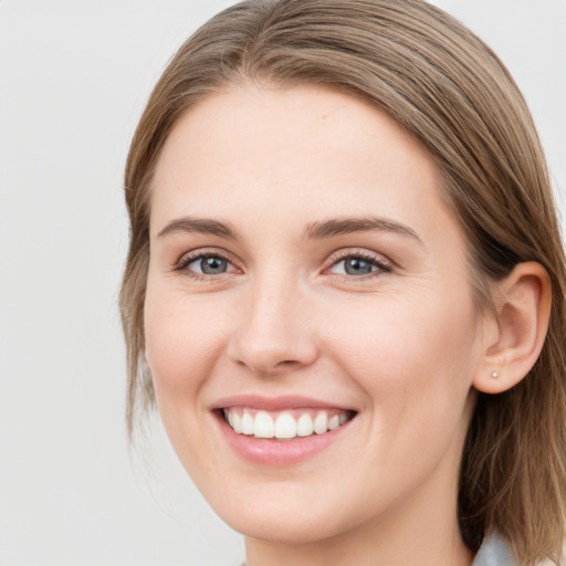 Joyful white young-adult female with long  brown hair and blue eyes