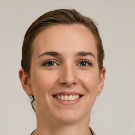 Joyful white young-adult female with short  brown hair and grey eyes