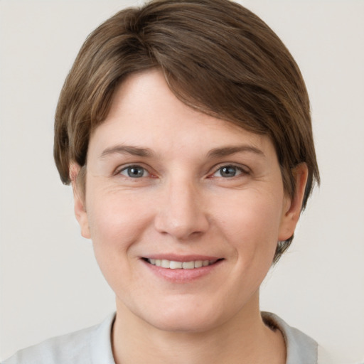 Joyful white young-adult female with short  brown hair and grey eyes