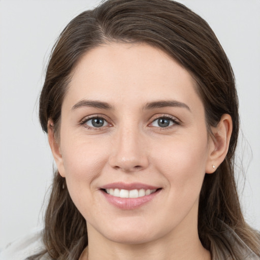 Joyful white young-adult female with long  brown hair and grey eyes