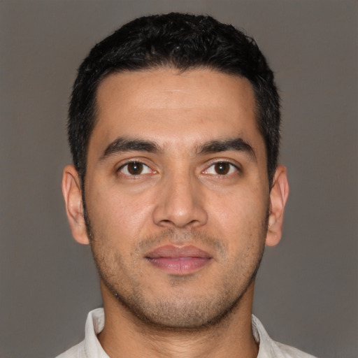 Joyful white young-adult male with short  black hair and brown eyes