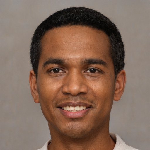 Joyful black young-adult male with short  black hair and brown eyes