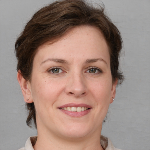 Joyful white adult female with medium  brown hair and grey eyes