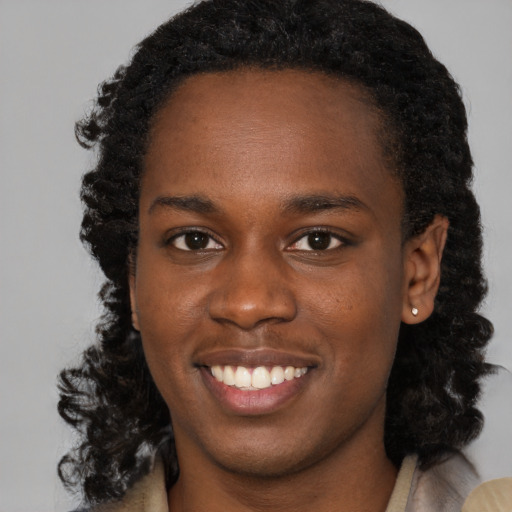 Joyful black young-adult female with long  black hair and brown eyes