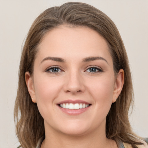 Joyful white young-adult female with medium  brown hair and grey eyes