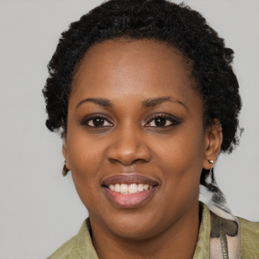 Joyful black young-adult female with short  black hair and brown eyes