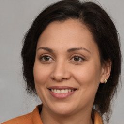 Joyful white adult female with medium  brown hair and brown eyes