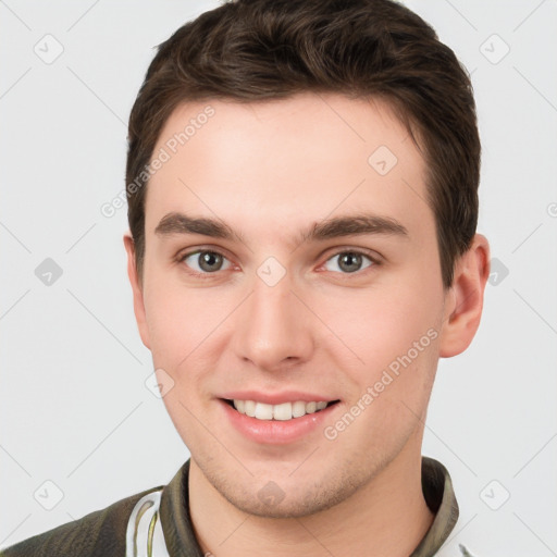 Joyful white young-adult male with short  brown hair and grey eyes