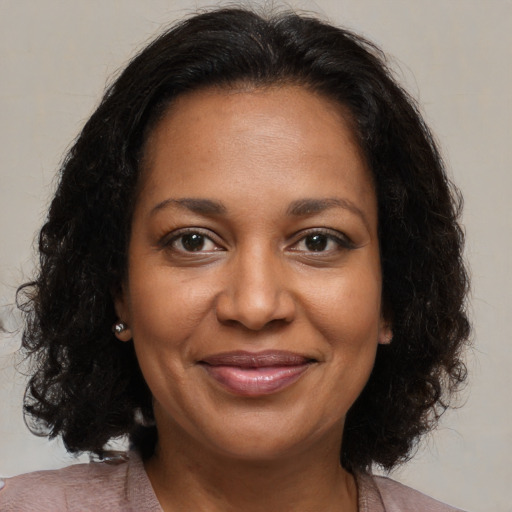 Joyful black adult female with medium  brown hair and brown eyes