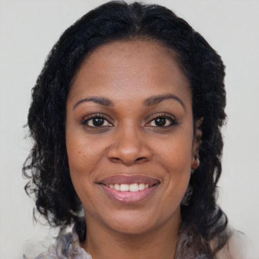 Joyful black young-adult female with medium  brown hair and brown eyes