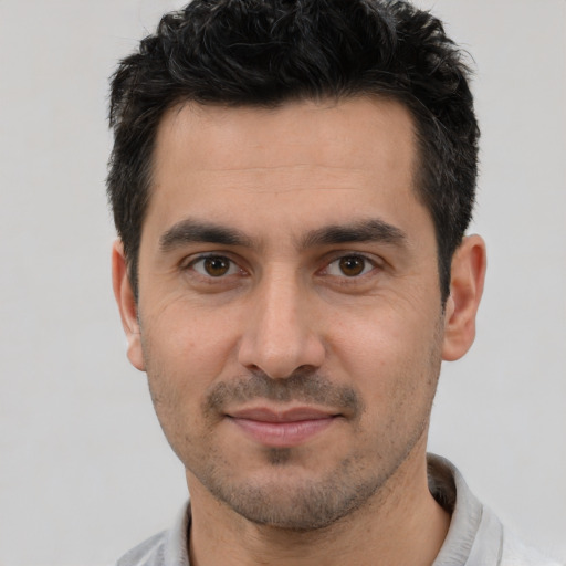 Joyful white young-adult male with short  black hair and brown eyes