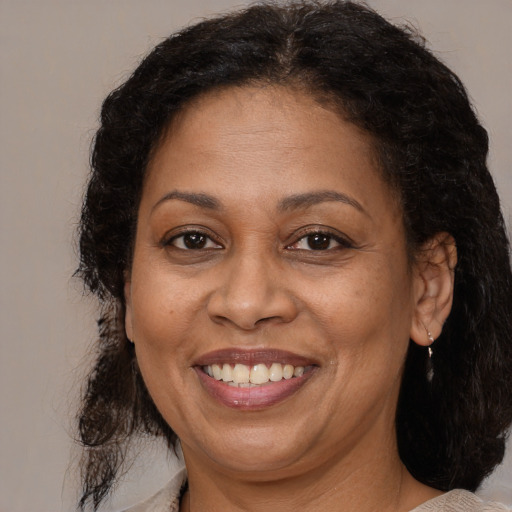 Joyful latino adult female with medium  brown hair and brown eyes