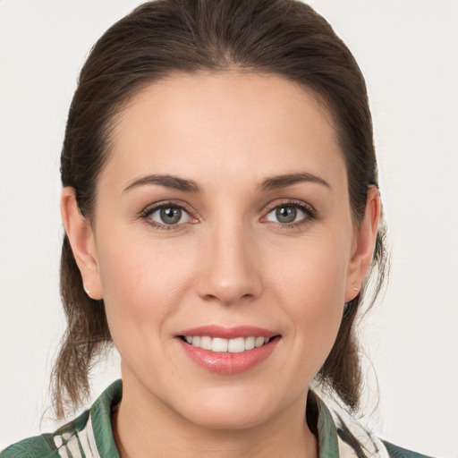 Joyful white young-adult female with medium  brown hair and grey eyes