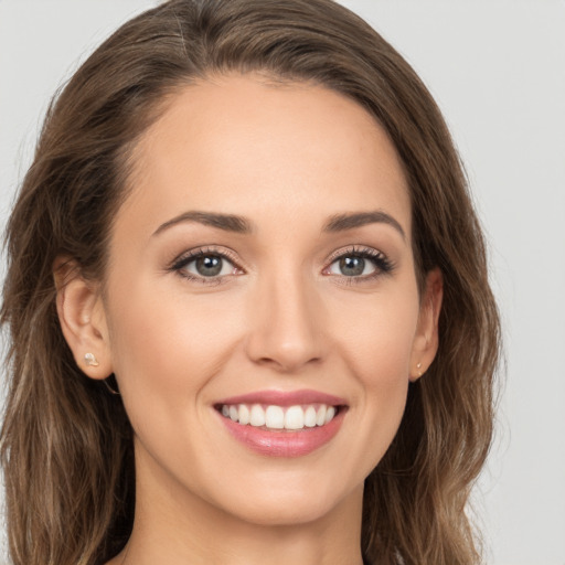 Joyful white young-adult female with long  brown hair and brown eyes