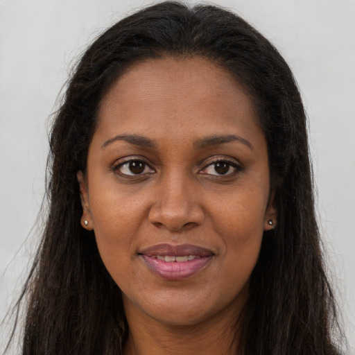 Joyful black young-adult female with long  brown hair and brown eyes