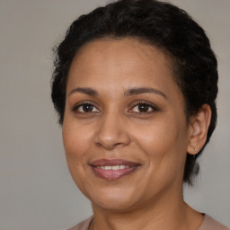 Joyful latino adult female with medium  brown hair and brown eyes