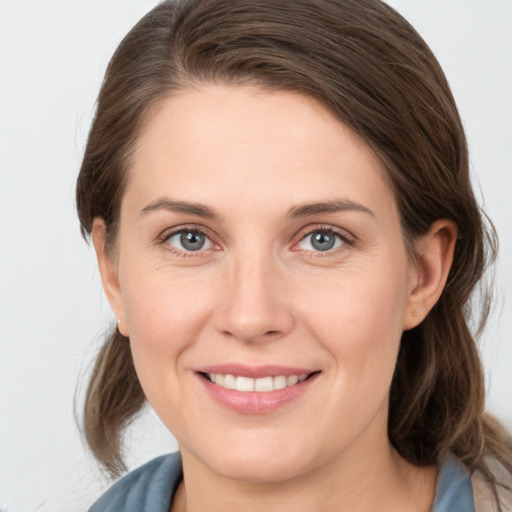 Joyful white young-adult female with medium  brown hair and grey eyes