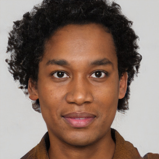 Joyful black young-adult male with short  brown hair and brown eyes