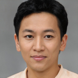 Joyful asian young-adult male with short  black hair and brown eyes