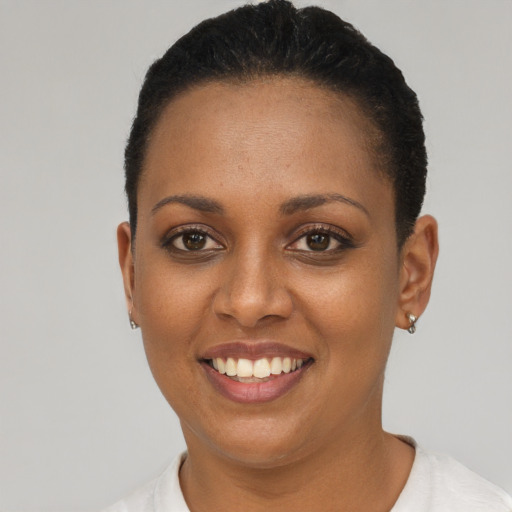 Joyful black young-adult female with short  brown hair and brown eyes
