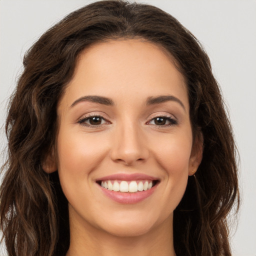 Joyful white young-adult female with long  brown hair and brown eyes