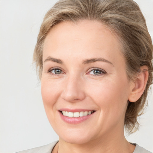 Joyful white young-adult female with medium  brown hair and blue eyes