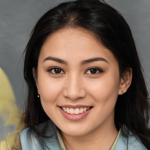 Joyful latino young-adult female with long  brown hair and brown eyes