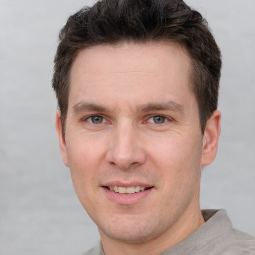 Joyful white adult male with short  brown hair and grey eyes