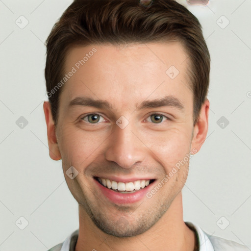 Joyful white young-adult male with short  brown hair and grey eyes