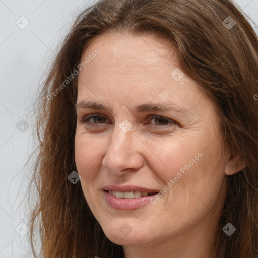 Joyful white adult female with long  brown hair and brown eyes