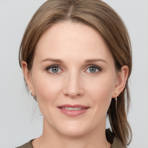 Joyful white young-adult female with medium  brown hair and grey eyes