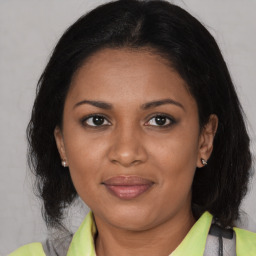 Joyful black adult female with medium  brown hair and brown eyes