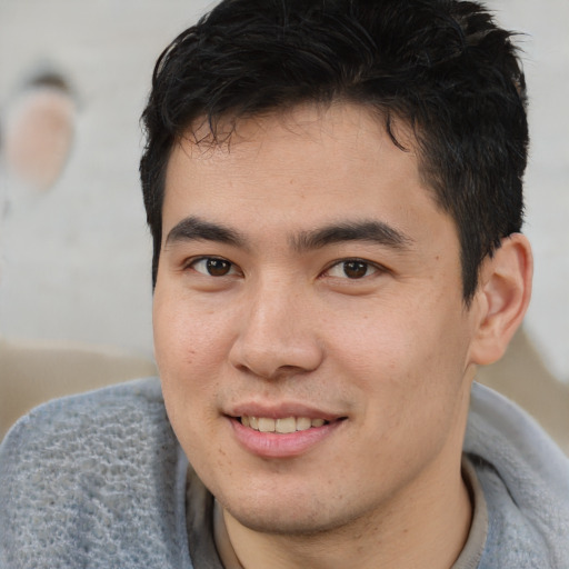 Joyful latino young-adult male with short  brown hair and brown eyes