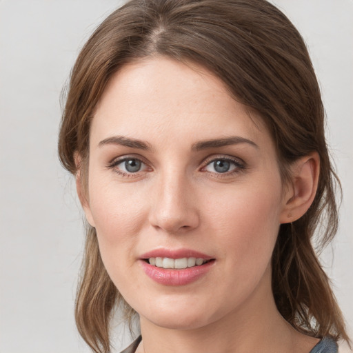 Joyful white young-adult female with medium  brown hair and grey eyes