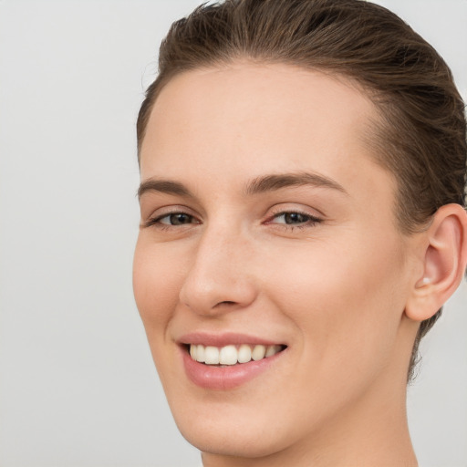 Joyful white young-adult female with short  brown hair and grey eyes