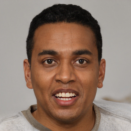Joyful black young-adult male with short  black hair and brown eyes