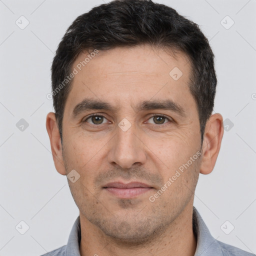 Joyful white adult male with short  black hair and brown eyes