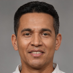 Joyful latino adult male with short  black hair and brown eyes