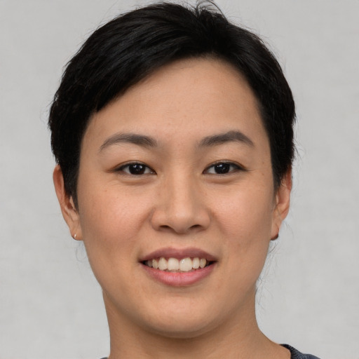 Joyful asian young-adult female with short  black hair and brown eyes