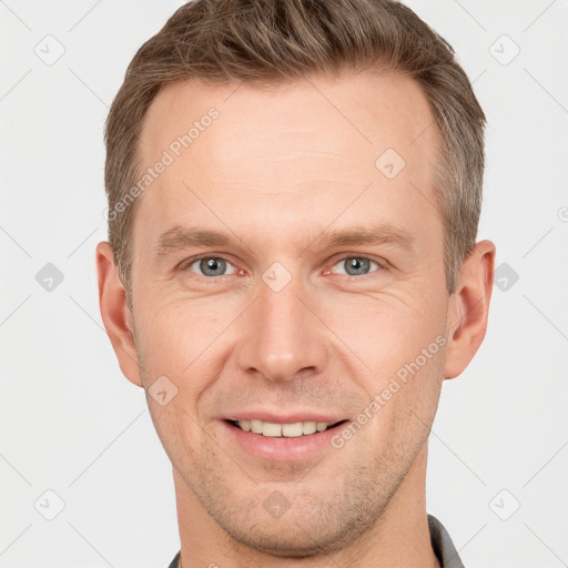 Joyful white young-adult male with short  brown hair and grey eyes