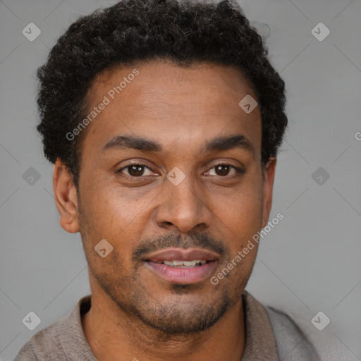 Joyful black young-adult male with short  brown hair and brown eyes