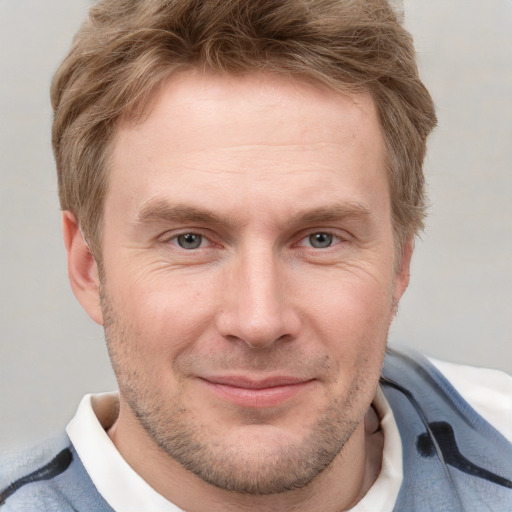 Joyful white adult male with short  brown hair and grey eyes