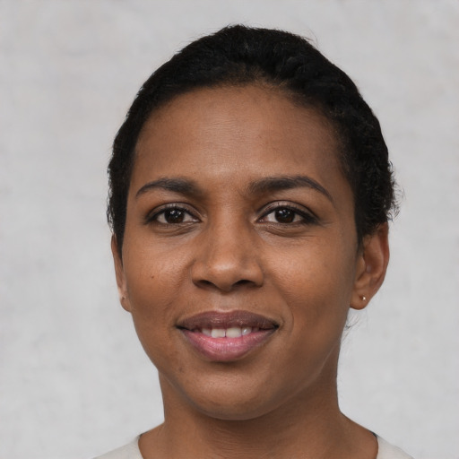 Joyful black young-adult female with short  black hair and brown eyes