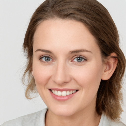 Joyful white young-adult female with medium  brown hair and blue eyes