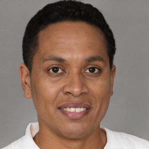 Joyful black adult male with short  black hair and brown eyes