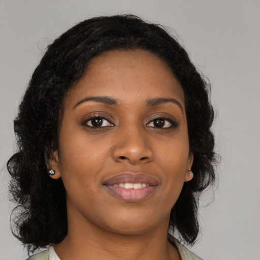 Joyful black young-adult female with long  black hair and brown eyes